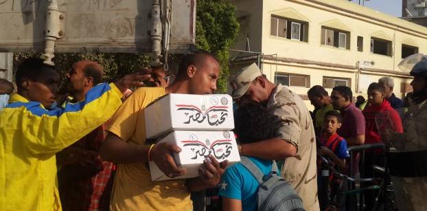 بالصور - مواطنون يتزاحمون أمام سيارات الجيش لشراء كرتونة "تحيا مصر"
