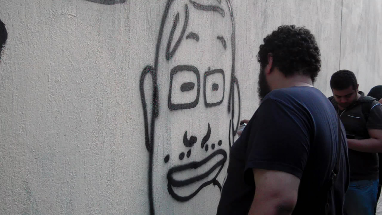 (محدث) بالفيديو- نشطاء يعيدون رسم جرافيتي على سور الجامعة الأمريكية 
