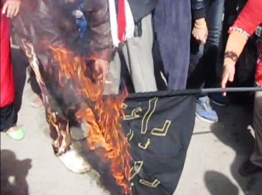 متظاهرون يحرقون علم 